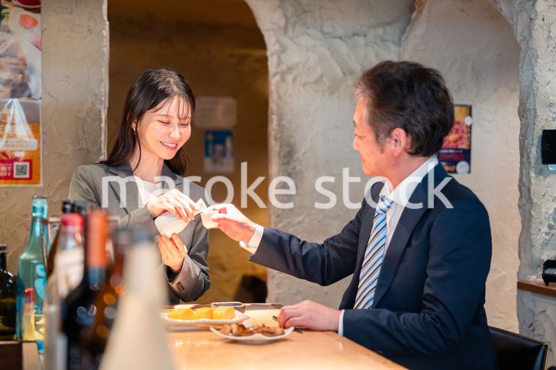 女性とお酒を飲むシニアのビジネスマン