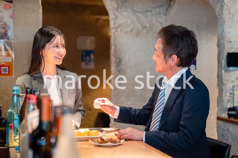 女性とお酒を飲むシニアのビジネスマン