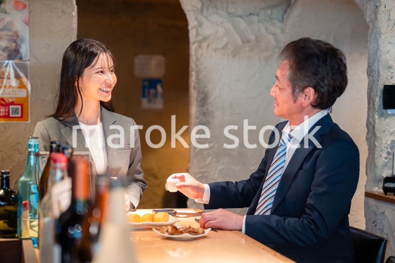 女性とお酒を飲むシニアのビジネスマン