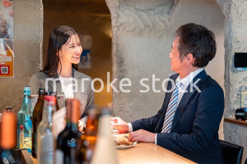 女性とお酒を飲むシニアのビジネスマン