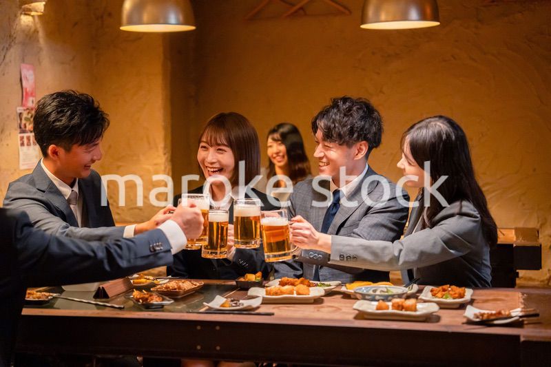 居酒屋で盛大に乾杯をするビジネスパーソン