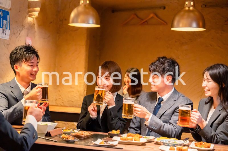 居酒屋で盛大に乾杯をするビジネスパーソン