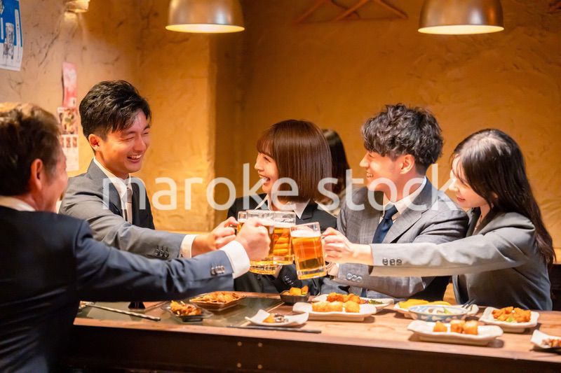 居酒屋で盛大に乾杯をするビジネスパーソン