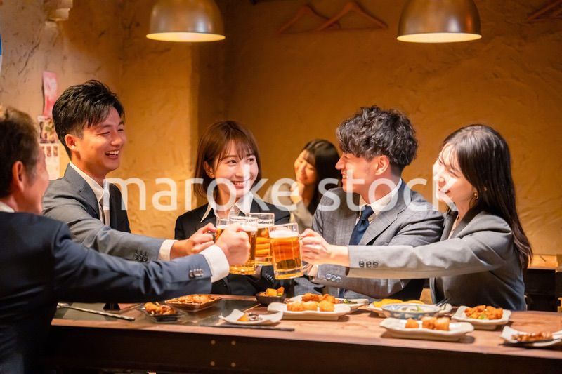居酒屋で盛大に乾杯をするビジネスパーソン
