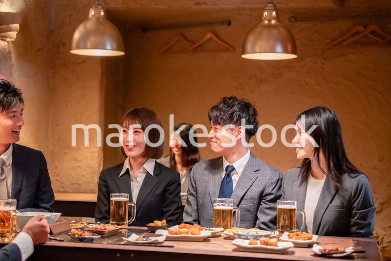 居酒屋で新入社員の歓迎会をするビジネスパーソン