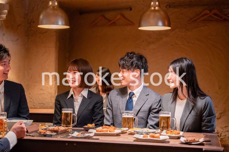 居酒屋で新入社員の歓迎会をするビジネスパーソン