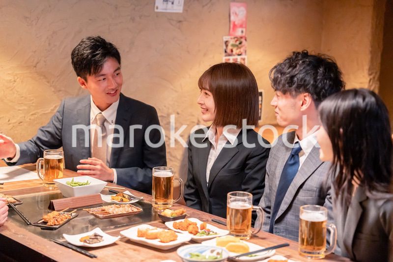 居酒屋で新入社員の歓迎会をするビジネスパーソン
