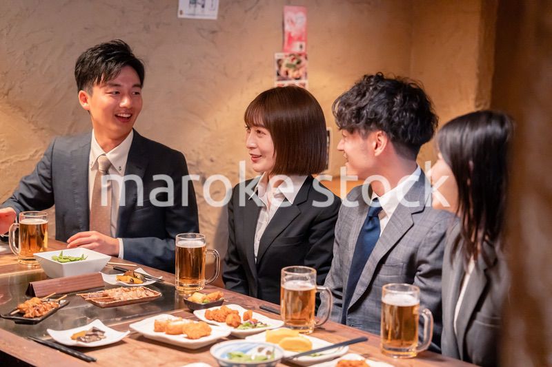 居酒屋で新入社員の歓迎会をするビジネスパーソン