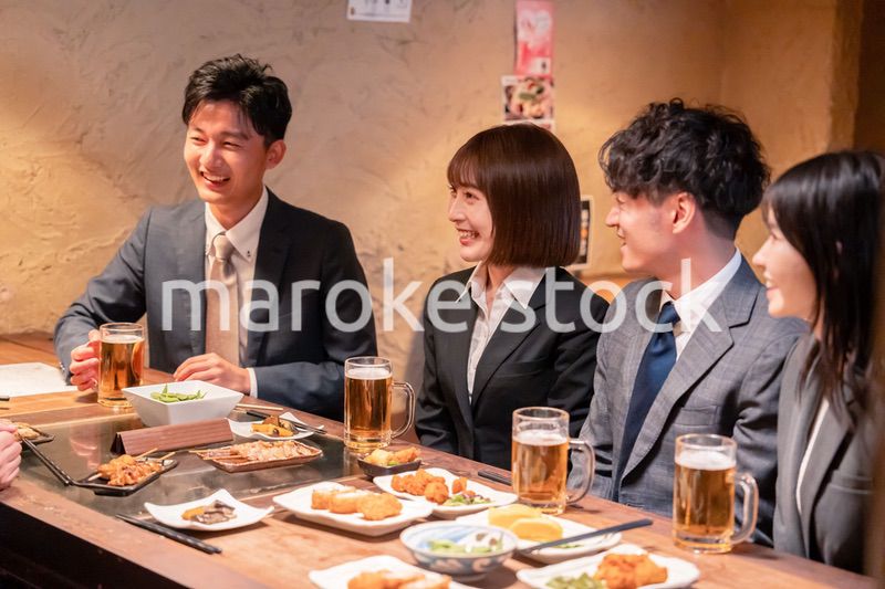 居酒屋で新入社員の歓迎会をするビジネスパーソン