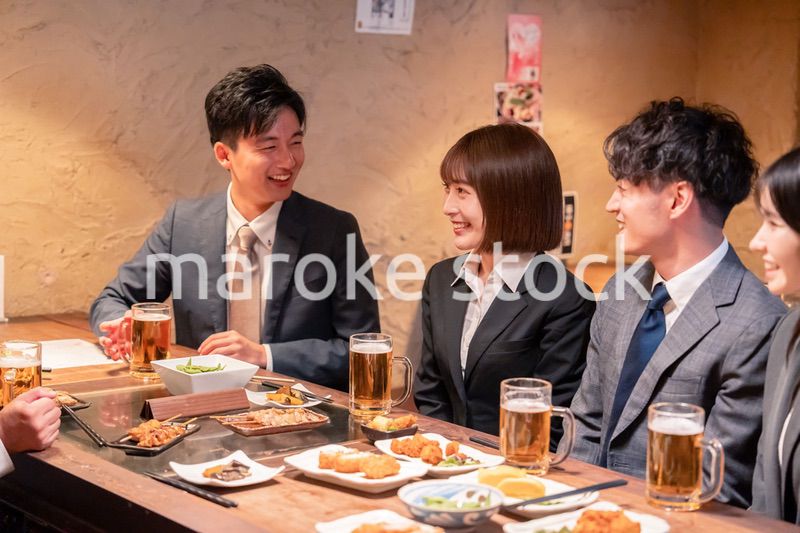 居酒屋で新入社員の歓迎会をするビジネスパーソン