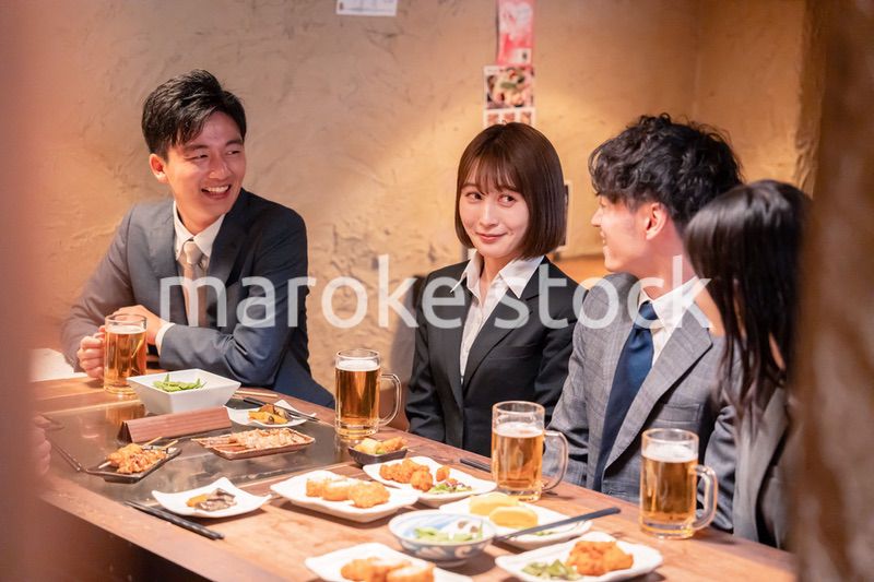 居酒屋で新入社員の歓迎会をするビジネスパーソン