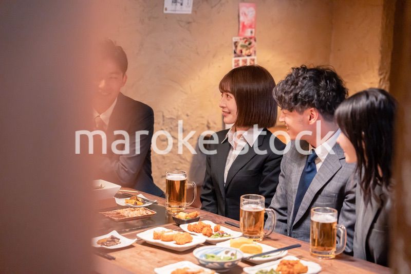 居酒屋で新入社員の歓迎会をするビジネスパーソン