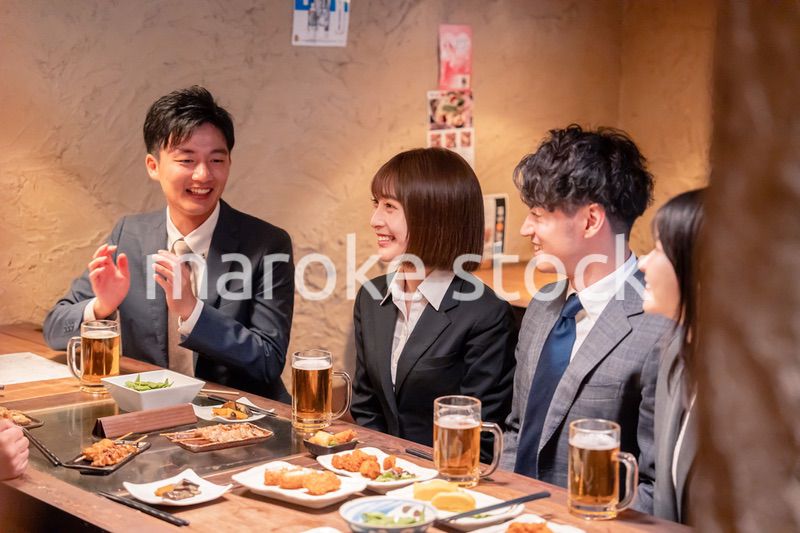 居酒屋で新入社員の歓迎会をするビジネスパーソン