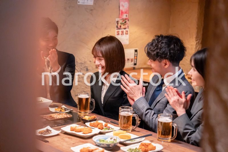 居酒屋で新入社員の歓迎会をするビジネスパーソン