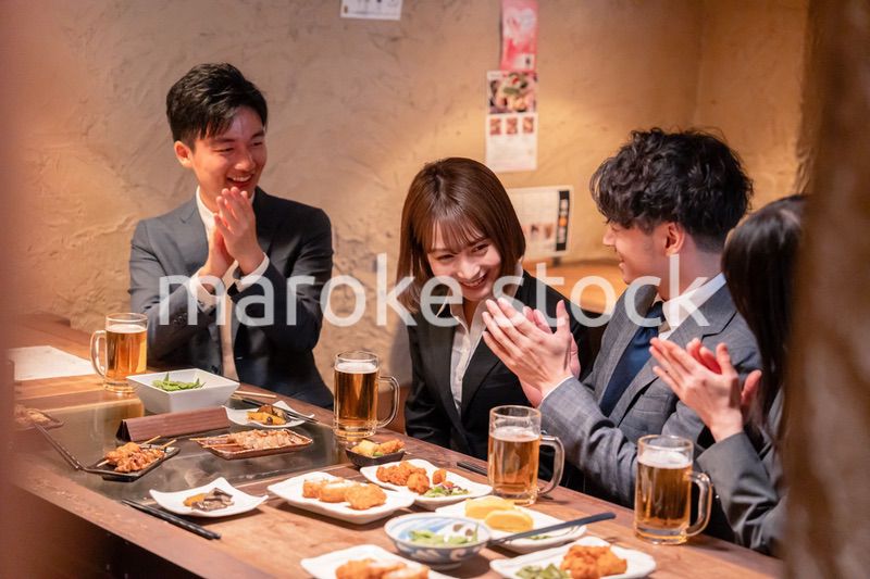 居酒屋で新入社員の歓迎会をするビジネスパーソン