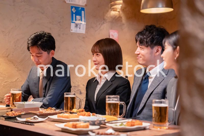 居酒屋で新入社員の歓迎会をするビジネスパーソン