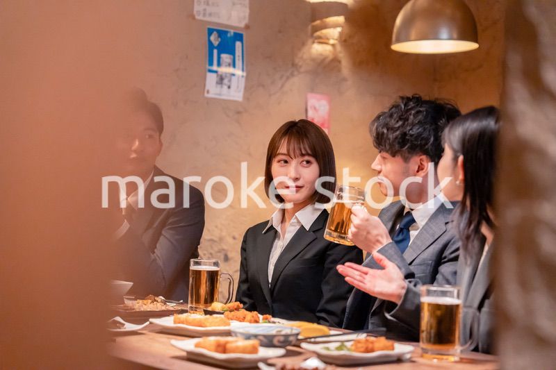 居酒屋で新入社員の歓迎会をするビジネスパーソン