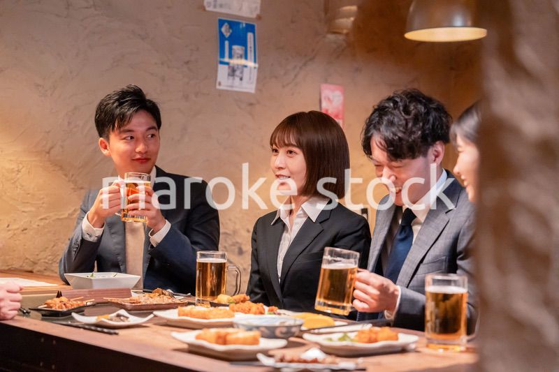 居酒屋で新入社員の歓迎会をするビジネスパーソン