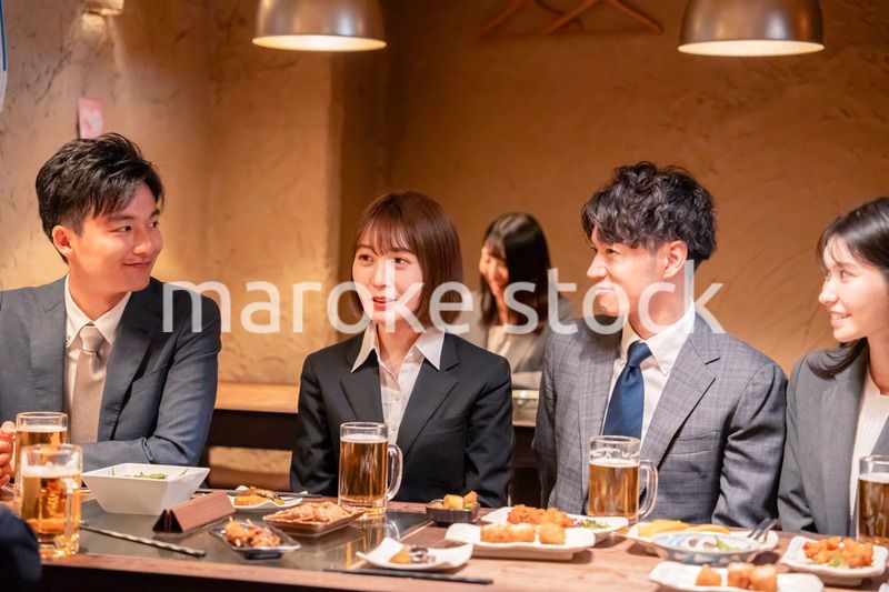 居酒屋で新入社員の歓迎会をするビジネスパーソン