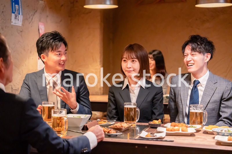 居酒屋で新入社員の歓迎会をするビジネスパーソン