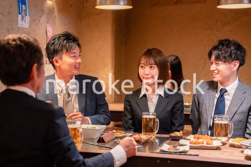 居酒屋で新入社員の歓迎会をするビジネスパーソン