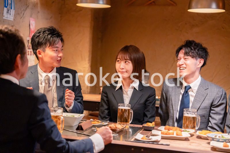 居酒屋で新入社員の歓迎会をするビジネスパーソン