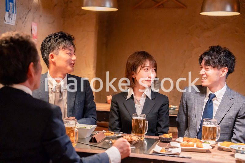 居酒屋で新入社員の歓迎会をするビジネスパーソン