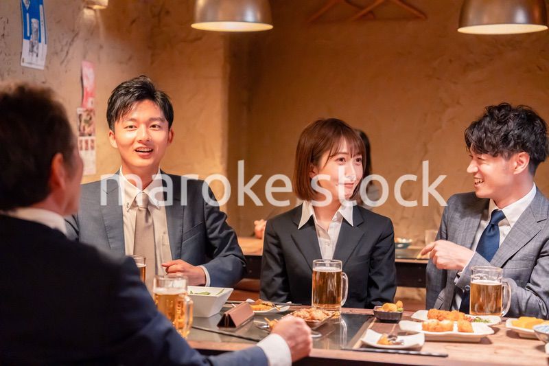 居酒屋で新入社員の歓迎会をするビジネスパーソン