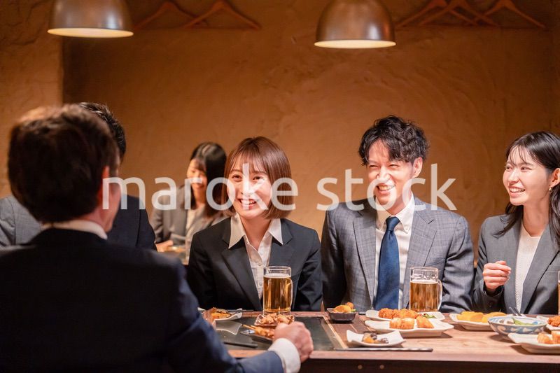 居酒屋で新入社員の歓迎会をするビジネスパーソン
