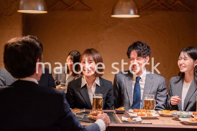 居酒屋で新入社員の歓迎会をするビジネスパーソン
