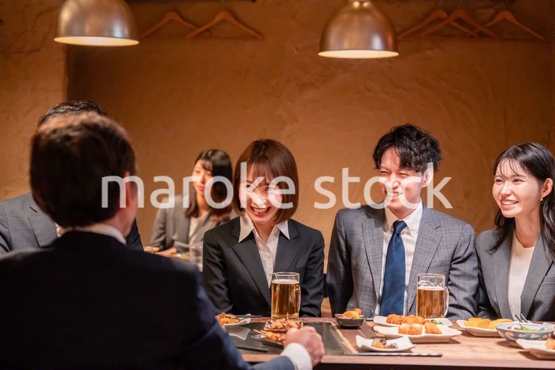 居酒屋で新入社員の歓迎会をするビジネスパーソン