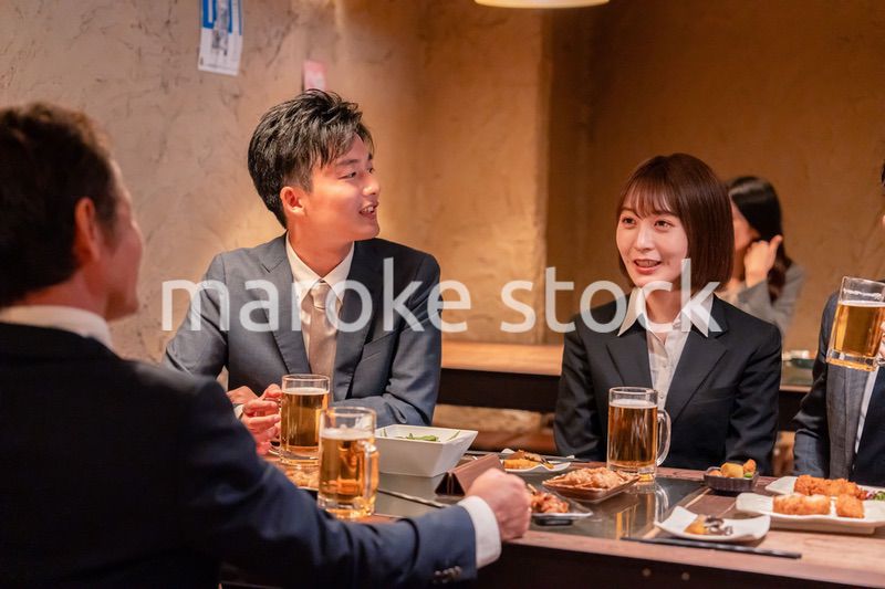 居酒屋で新入社員の歓迎会をするビジネスパーソン