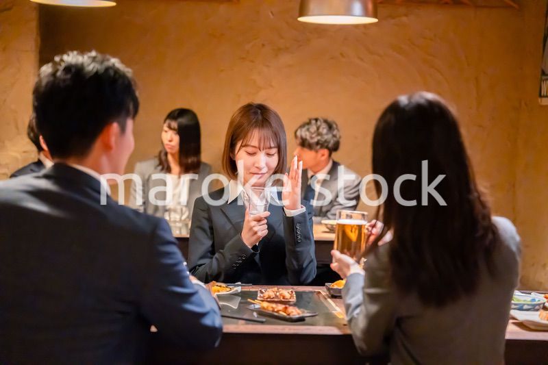 居酒屋で先輩社員にアルコールを勧められて断る女性社員