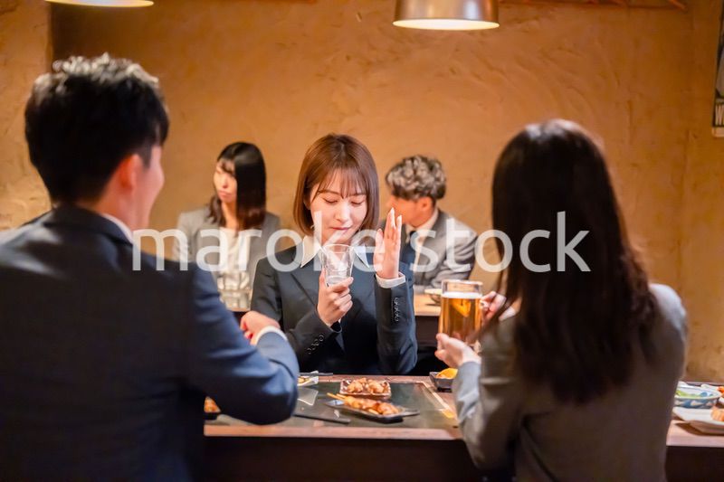 居酒屋で先輩社員にアルコールを勧められて断る女性社員