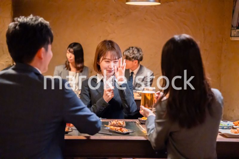居酒屋で先輩社員にアルコールを勧められて断る女性社員