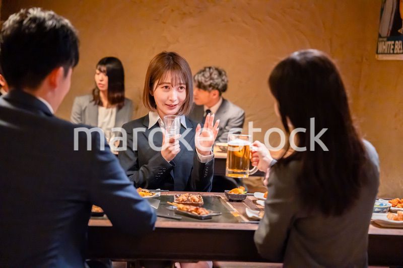 居酒屋で先輩社員にアルコールを勧められて断る女性社員