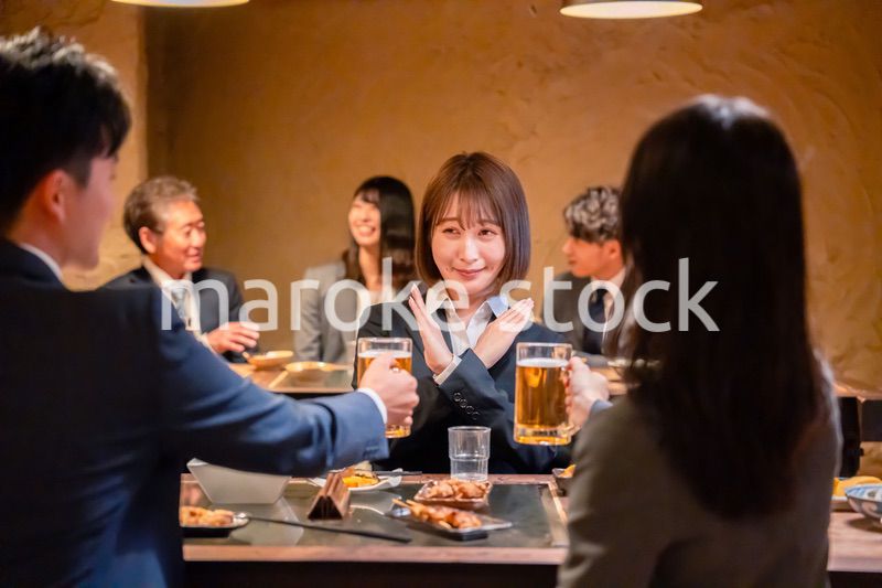 居酒屋で先輩社員にアルコールを勧められて断る女性社員