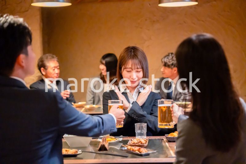 居酒屋で先輩社員にアルコールを勧められて断る女性社員
