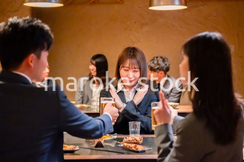 居酒屋で先輩社員にアルコールを勧められて断る女性社員