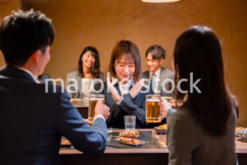 居酒屋で先輩社員にアルコールを勧められて断る女性社員