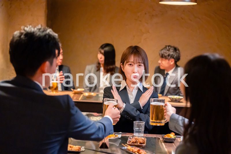 居酒屋で先輩社員にアルコールを勧められて断る女性社員