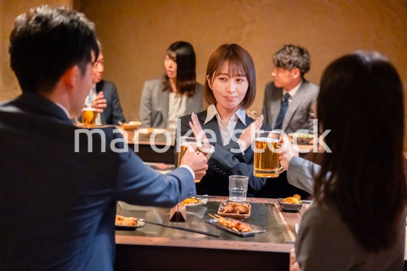 居酒屋で先輩社員にアルコールを勧められて断る女性社員