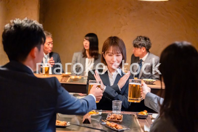 居酒屋で先輩社員にアルコールを勧められて断る女性社員