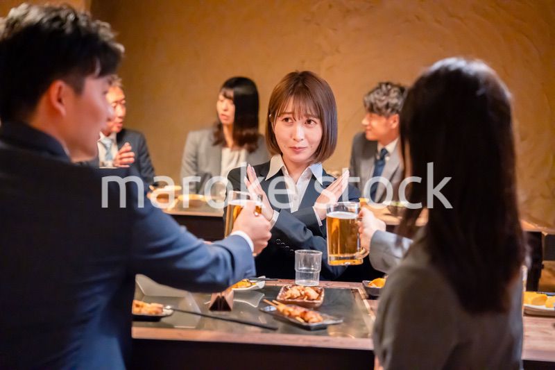 居酒屋で先輩社員にアルコールを勧められて断る女性社員