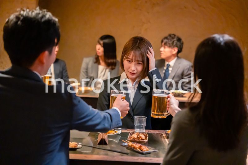 居酒屋で先輩社員にアルコールを勧められて断る女性社員