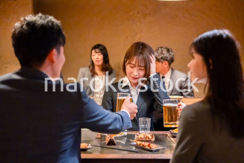 居酒屋で先輩社員にアルコールを勧められて断る女性社員