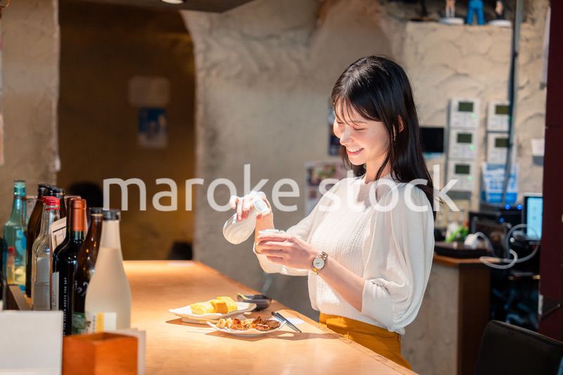お店で一人でお酒を楽しむ女性