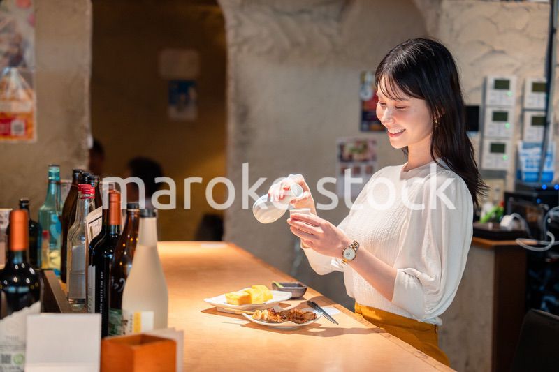 お店で一人でお酒を楽しむ女性