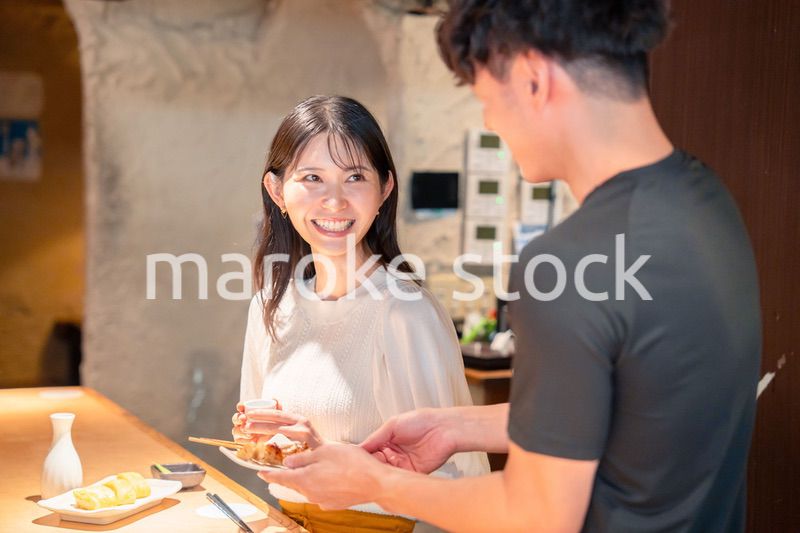 焼き鳥屋さんの女性客と店員