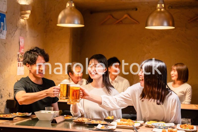 居酒屋でお酒を飲む若い男女